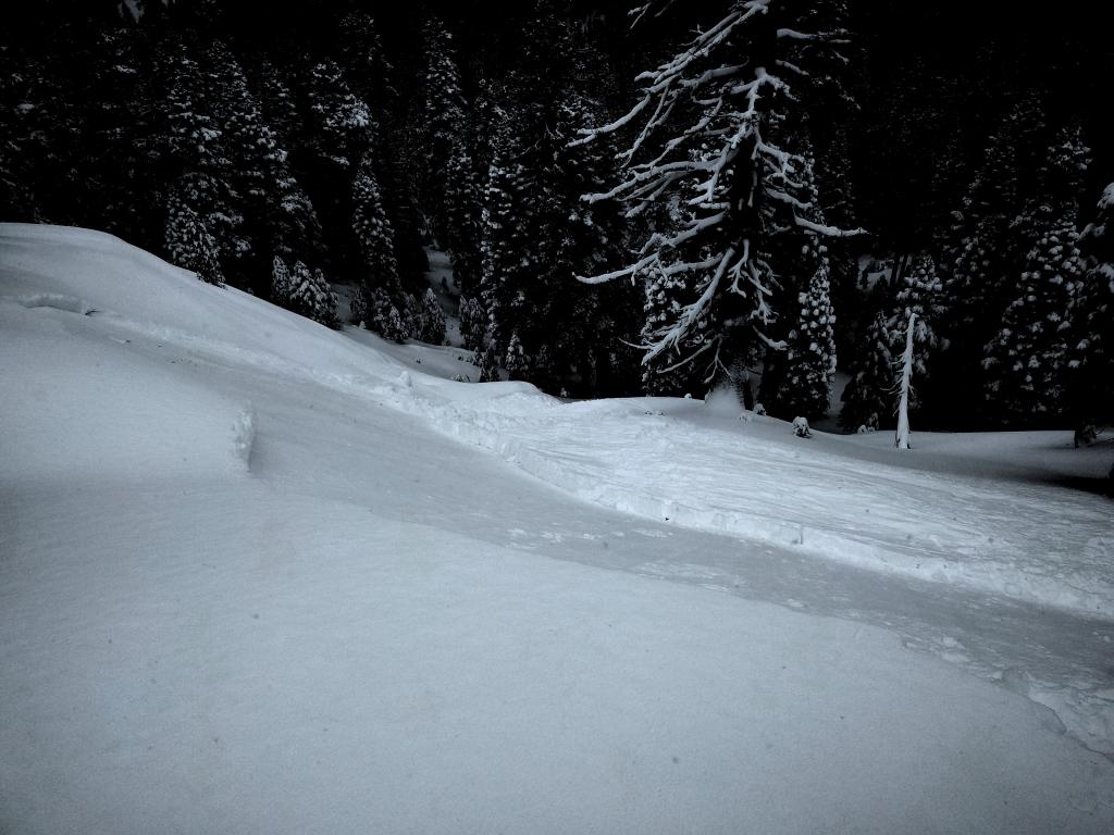  Looking down the path at the debris and <a href="/avalanche-terms/terrain-trap" title="Terrain in which the consequences of an avalanche are especially hazardous, such as a gully, an abrupt transition, an avalanche path that terminates in trees, a crevasse field or a cliff." class="lexicon-term">terrain traps</a> below. 