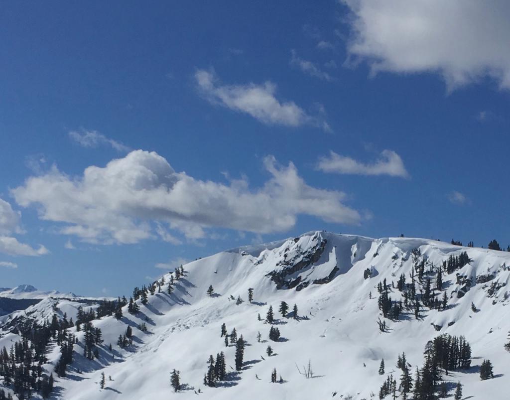  Large <a href="/avalanche-terms/cornice" title="A mass of snow deposited by the wind, often overhanging, and usually near a sharp terrain break such as a ridge. Cornices can break off unexpectedly and should be approached with caution." class="lexicon-term">cornices</a> with old debris on Echo Peak looking ominous during the warmth of the day. 