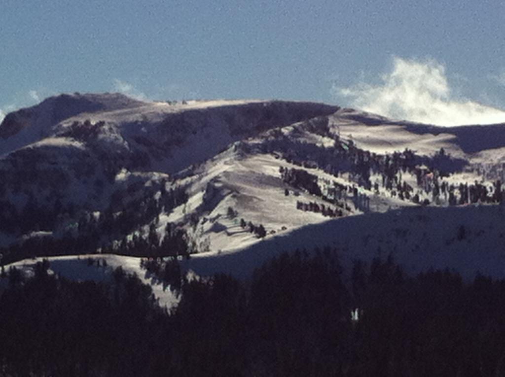  Over hanging <a href="/avalanche-terms/cornice" title="A mass of snow deposited by the wind, often overhanging, and usually near a sharp terrain break such as a ridge. Cornices can break off unexpectedly and should be approached with caution." class="lexicon-term">cornices</a> forming at the bottom of the picture along the ridge line. 