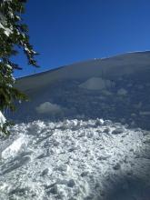 Large intentionally skier-triggered cornice collapse. The impact and weight of the cornice did not produce cracking in the wind-loaded test slope. Ski poles are in the photo for scale.