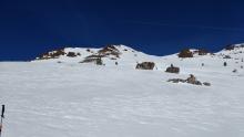 Rough wind sculpted snow surfaces on S aspect terrain above treeline.