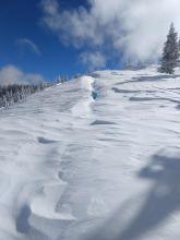 Deep crack behind a cornice that has pulled away from the ridge.