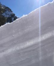 Backlit cross section of snow adjacent to avalanche crown.
