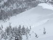 Cornice collapses partially covered by additional new snow.