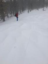 A long shooting crack on an open slope loaded by NE winds. The crack goes from where the photo was taken to the person in the red jacket.