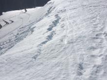 Large cracks developing behind cornices as they sag from ridges.