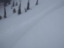 Debris and bed surface covered by additional storm snow and wind blown snow