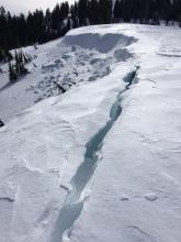 Large cracks developing behind cornices along ridgelines.