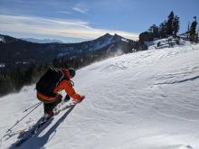 Brandon looking at the facets under the wind crust in exposed upper elevation terrain.