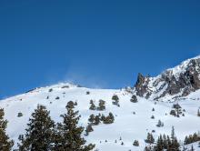 Plumes of wind blown snow seen from many big terrain features in the afternoon