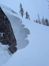 Cool wind drifted snow feature near a boulder.