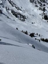 Shooting cracks near snow machine track and a number of avalanche deposits in background. 