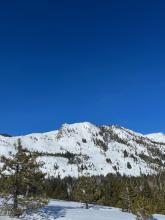 There were several large old wet loose slides on and adjacent to Flagpole. At the time I took this photo there were plumes of wind driven snow swirling around the summit and over the old wet loose debris. 