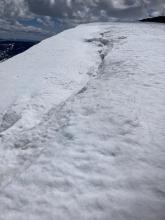 Large deep cracks opening up as cornices pull away from ridges.